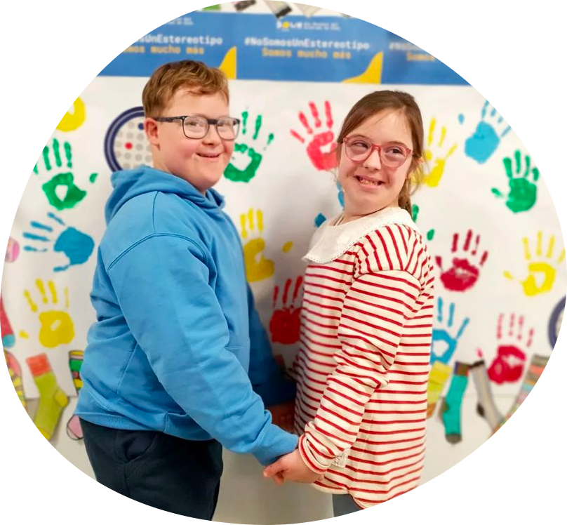 Imagen ilustrativa de los objetivos de nuestra asociación, presenta a un niño y una niña con Síndrome de Down cogidos de la mano.
